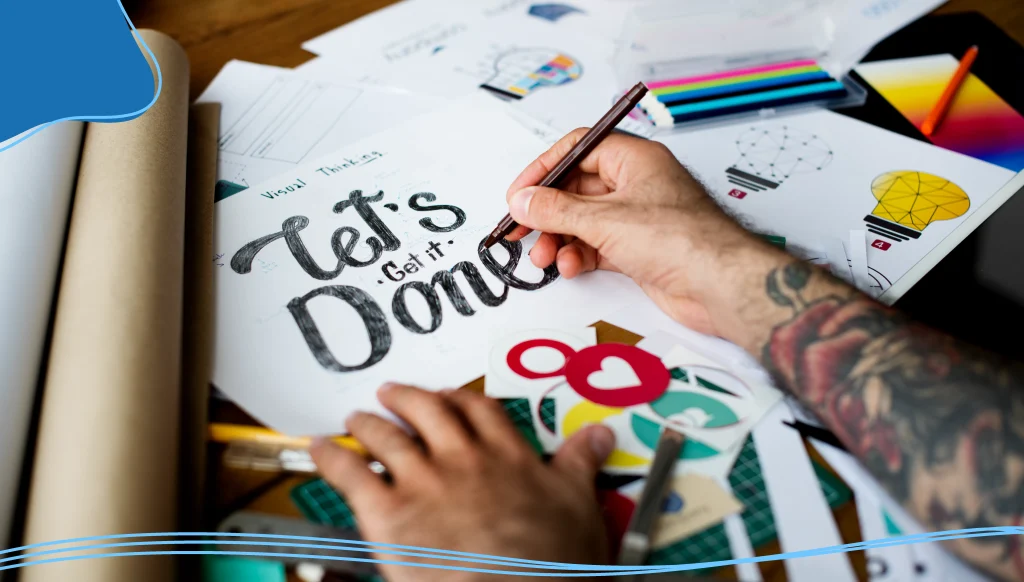 Hands Writing Let's Get It Done Phrase on Paper